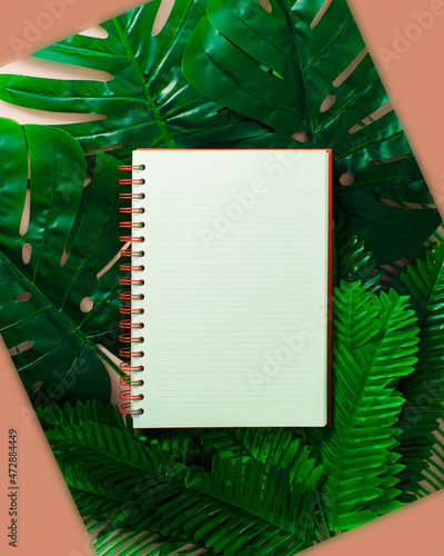 Creative layout made of colorful green tropical leaves and palms on beige background. Minimal business exotic concept with copy space. Border arrangement background. photo