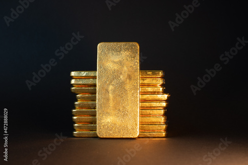 Gold bullion bars on black background. Stack of large cast investment gold ingots. Swiss gold. Business and finance. Investing into precious metals. photo