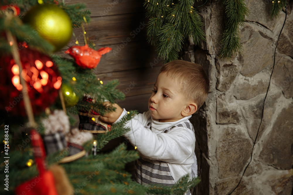little boy playing against the background of new year decorations
