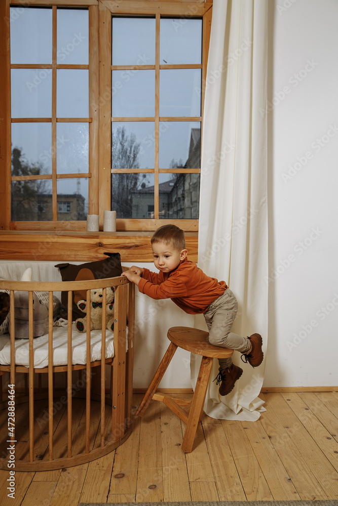 little boy playing in the room in a brown sweater little boy playing in the room in a brown sweater