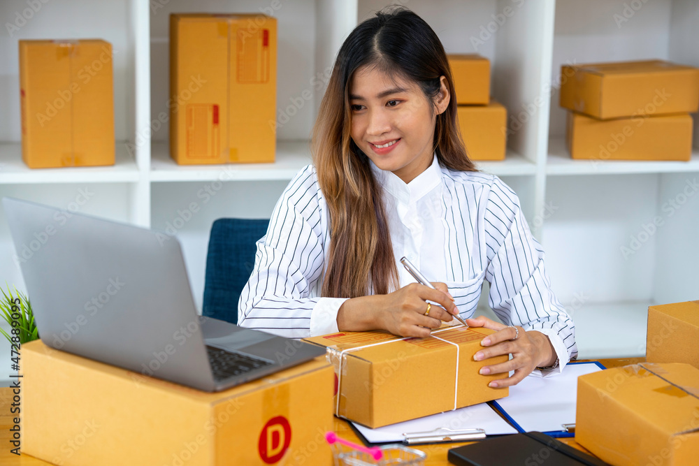 Starting Small business entrepreneur SME freelance,Portrait young woman working at home office, BOX,smartphone,laptop, online, marketing, packaging, delivery, SME, e-commerce concept Starting Small business entrepreneur SME freelance,Portrait young woman working at home office, BOX,smartphone,laptop, online, marketing, packaging, delivery, SME, e-commerce concept