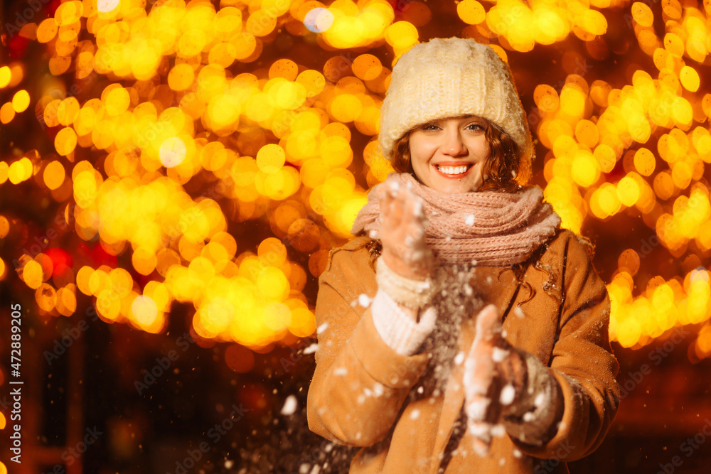 Young woman walks through the night winter city. Light around. Winter fashion, holidays, rest, travel concept. Young woman walks through the night winter city. Light around. Winter fashion, holidays, rest, travel concept.