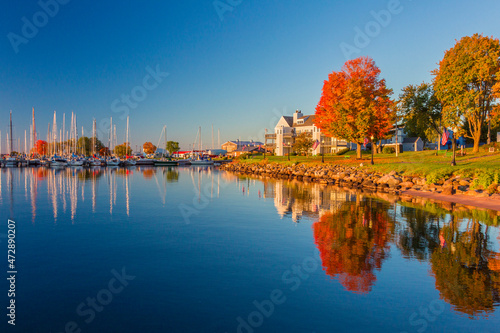 USA, Wisconsin. Fall colors reflected on the still waters of the harbor in Bayfield on Lake Superior. photo