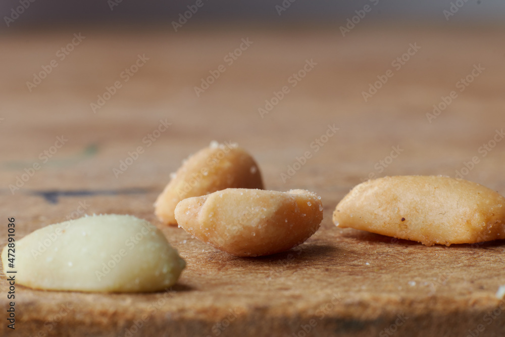macro photo of nuts on a wooden table, peanuts, beer snacks, blurred background