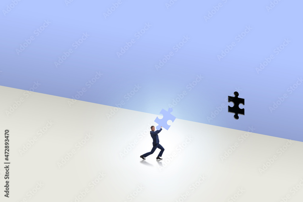 Businessman putting missing jigsaw puzzle piece Businessman putting missing jigsaw puzzle piece