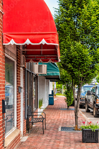 Fototapeta Naklejka Na Ścianę i Meble -  Mountain City main street road sidewalk in Johnson county Tennessee ski resort town city with restaurants stores shops with red brick architecture, cars driving