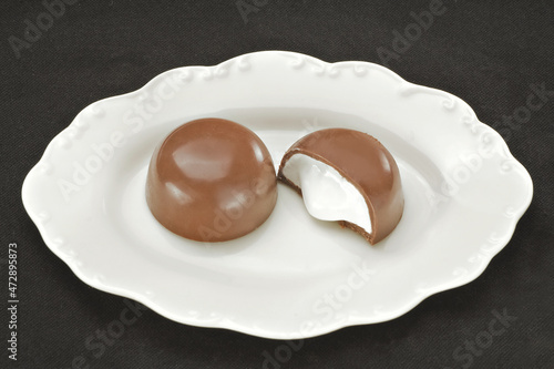 Chocolate em cima de um prato branco no fundo escuro photo