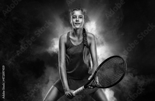 Tennis player. Beautiful girl teenager and athlete with racket in sporswear and hat on tennis court. Sport concept. © Mike Orlov