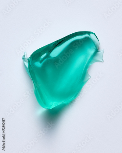 Drop of  green gel cosmetics product on white backdrop