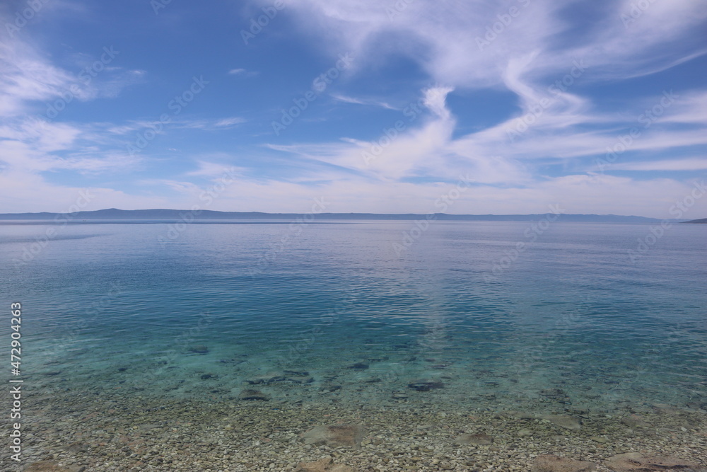 Seascape calm at sea and picturesque clouds on a summer sunny day on the coast of Croatia