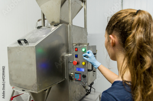 Woman working in industry, adjusting equipament photo