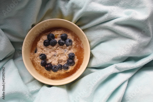 Porridge aux myrtilles et au miel sur un plaid pour un petit-déjeuner sain dès le matin