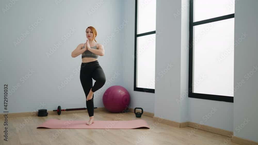 Young redhead woman smiling confident training yoga at sport center Young redhead woman smiling confident training yoga at sport center