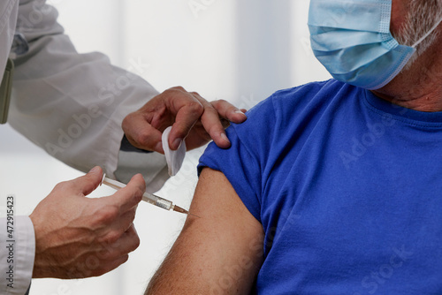 Elderly man receiving vaccine. Medical worker vaccinating senior patient against coronavirus, influenza, flu or pneumonia