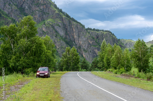 asphalt road between mountain peaks. warm summer day © Вячеслав 