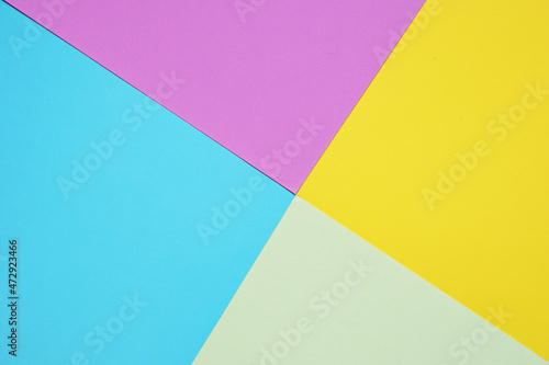 Blank light green paper, purple, yellow, and blue paper in geometric forms form an abstract background concept.