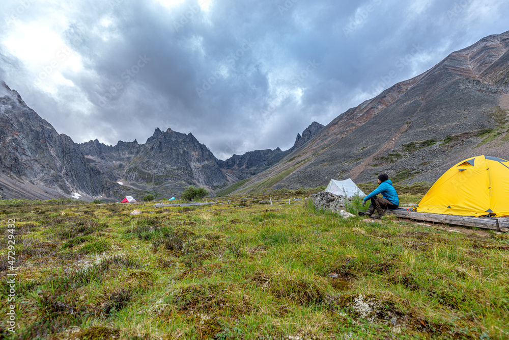 Man, hiker camping in Tombstone Territorial Park during summer time in Yukon Territory, Canada. 