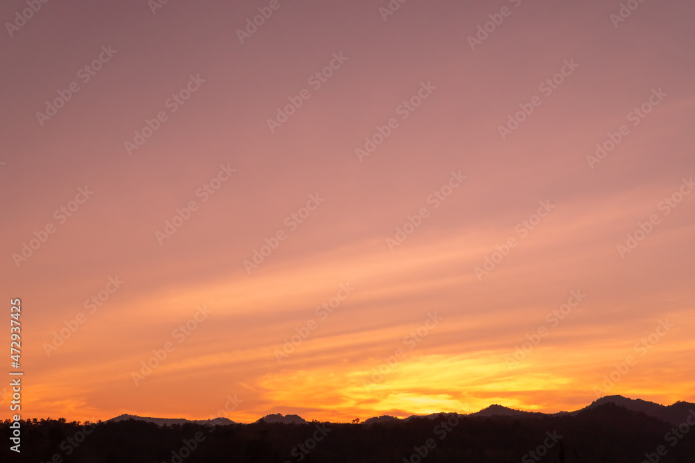 The twilight vanilla sky over the silhouette mountains peak