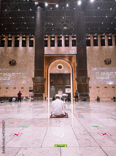 Central Jakarta, Indonesia - May 2th, 2021 : A Muslim man is praying in a mosque, more precisely at the Istiqlal mosque in Jakarta.