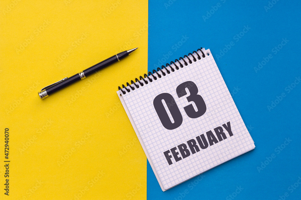 February 3rd. Day 3 of month. Calendar date. Notebook with a spiral and pen lies on a yellow-blue background February 3rd. Day 3 of month. Calendar date. Notebook with a spiral and pen lies on a yellow-blue background