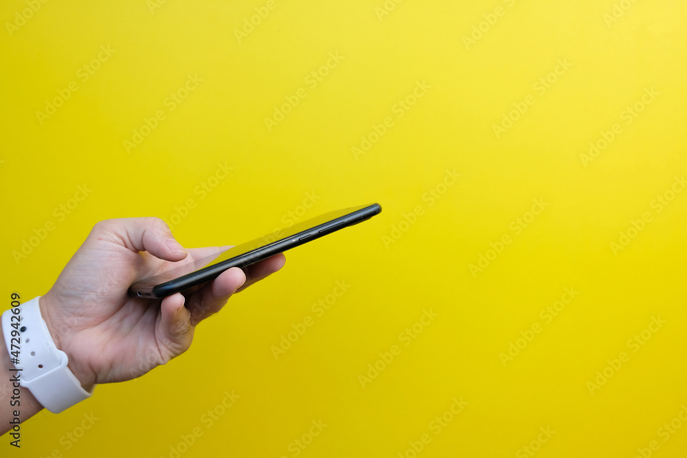 Hand uses a smartphone. In the office, a businessman is working. Freelancing, student life, e-learning, studying, web site, technology. Hand uses a smartphone. In the office, a businessman is working. Freelancing, student life, e-learning, studying, web site, technology.
