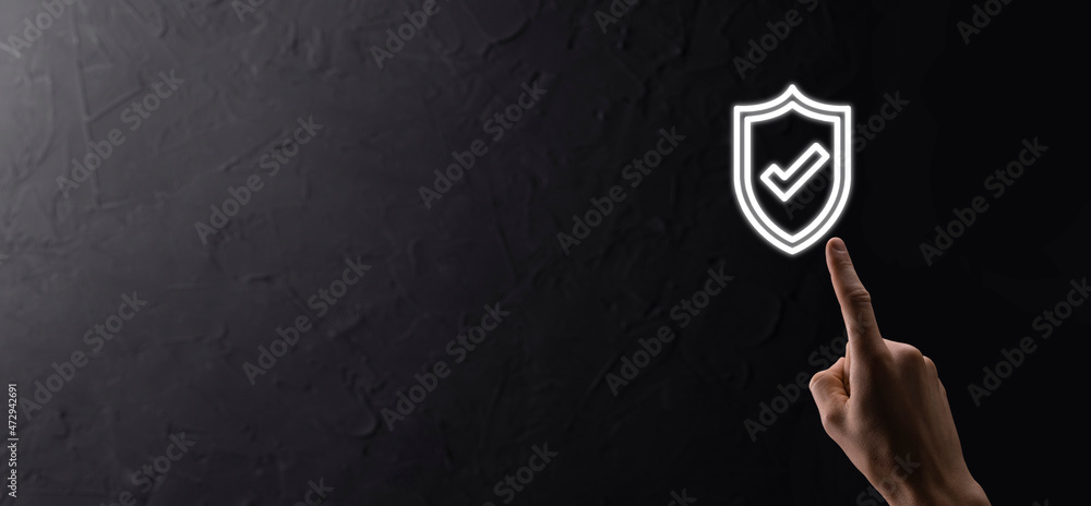 Male hand holding protect shield with a check mark icon on blue background. Protection network security computer and safe your data concept . Male hand holding protect shield with a check mark icon on blue background. Protection network security computer and safe your data concept .