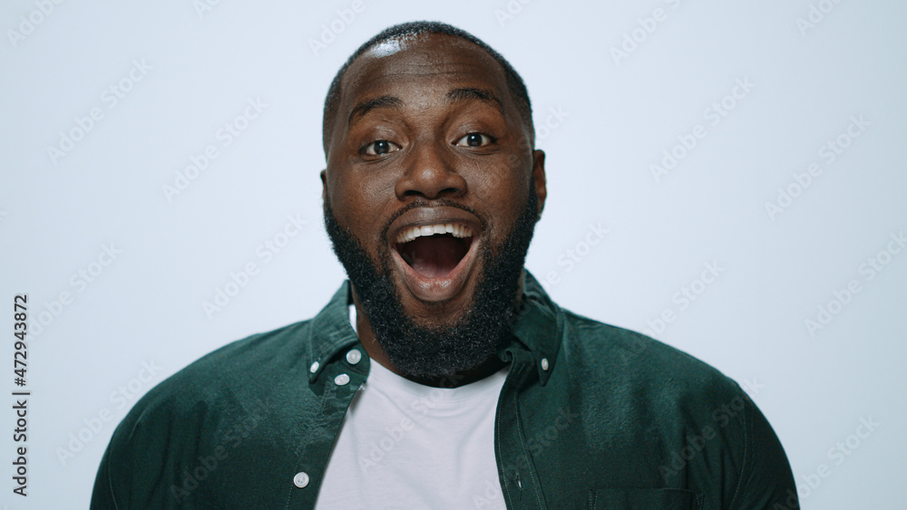 Portrait of surprised african guy covering mouth with hands in studio. Portrait of surprised african guy covering mouth with hands in studio.