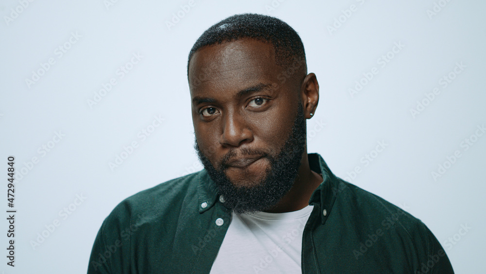 Obraz premium Portrait of smiling african american man winking eye on grey background.