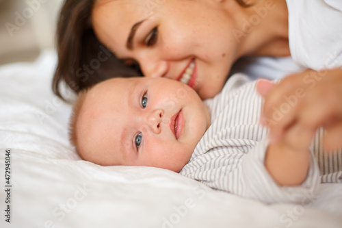 mom and baby are lying at home on the bed