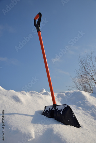 Clearing snow with shovel on sunny winter day