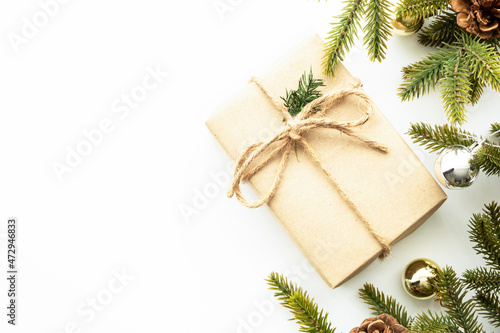 Beautiful Christmas background with gift box, decorate with pine branches over white background. Top view with copy space, flat lay.