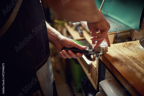 A barman's hands are preparing an espresso. Coffee, beverage, bar