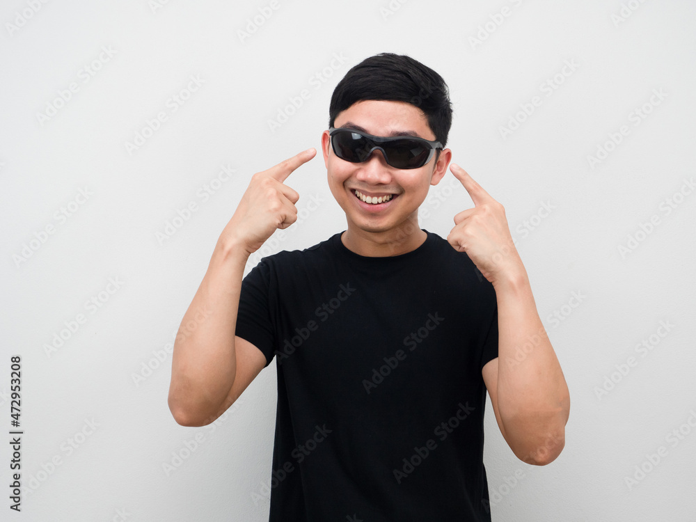 Asian man cheerful point finger at sunglasses on his face Asian man cheerful point finger at sunglasses on his face