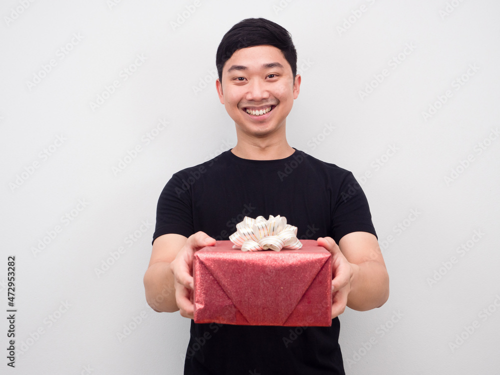Asian man smiling feeling happy giving gift box to you Asian man smiling feeling happy giving gift box to you
