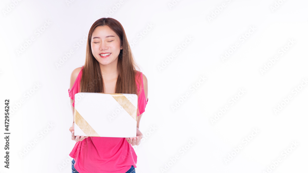 Friendly young woman with surprised excited screaming while holding gift box in her hands over isolated against white background. Excited teenager received surprise gift for celebrate or anniversary. Friendly young woman with surprised excited screaming while holding gift box in her hands over isolated against white background. Excited teenager received surprise gift for celebrate or anniversary.