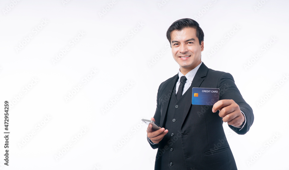 Success handsome businessman wear suit with tie showing credit card mockup and holding smartphone in own hand while standing over isolated white background. Payment transaction and financial concept. Success handsome businessman wear suit with tie showing credit card mockup and holding smartphone in own hand while standing over isolated white background. Payment transaction and financial concept.