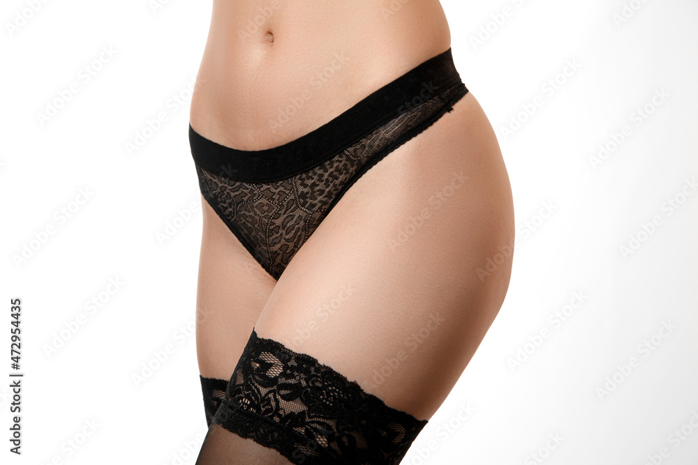 the body of a young beautiful nude girl with a good athletic body ,with a good abs on her stomach in black underwear on a white isolated background. the body of a young beautiful nude girl with a good athletic body ,with a good abs on her stomach in black underwear on a white isolated background.