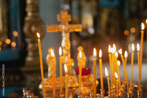 burning candles in church with a golden cross religious background. Inside a church. Russian othodox church.