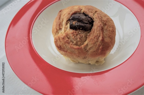Homemade chocolate muffin. On red plate