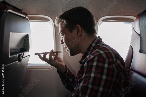 Tableau sur toile man speakerphone call on phone in seat of passenger on board of plane