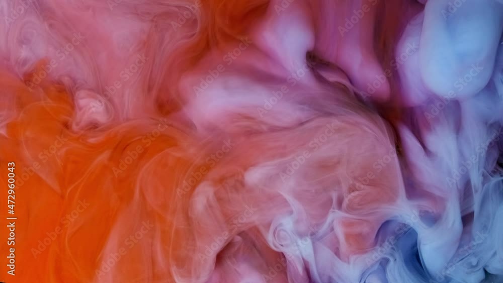 Color red and blue paint drops in water with black background , abstract color mix Color red and blue paint drops in water with black background , abstract color mix