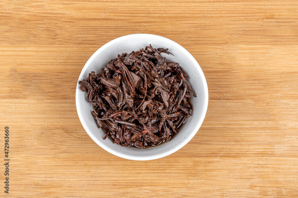 Top view of a white bowl with used tea leaves. Top view of a white bowl with used tea leaves.