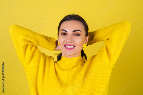 Young woman in a yellow cozy sweater on a background with bright pink glitter smiles sweetly, in a good mood, radiates a positive attitude © Анастасия Каргаполов