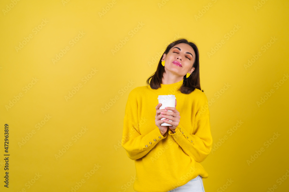 Young woman in a yellow cozy sweater with bright pink lip gloss with a paper cup of hot aromatic coffee, dreamily looks, cute smile, radiating warmth Young woman in a yellow cozy sweater with bright pink lip gloss with a paper cup of hot aromatic coffee, dreamily looks, cute smile, radiating warmth
