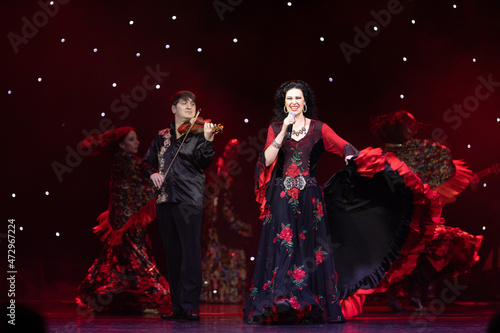 A team of musicians, singers and dancers in gypsy costumes singing and dancing on stage photo