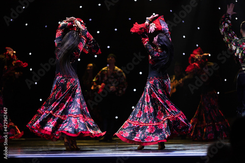 A team of musicians, singers and dancers in gypsy costumes singing and dancing on stage photo