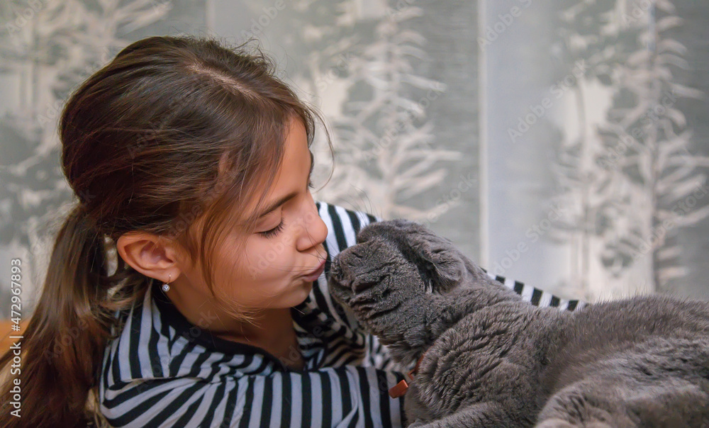 Child girl at home with a cat. Selective focus. Child girl at home with a cat. Selective focus.