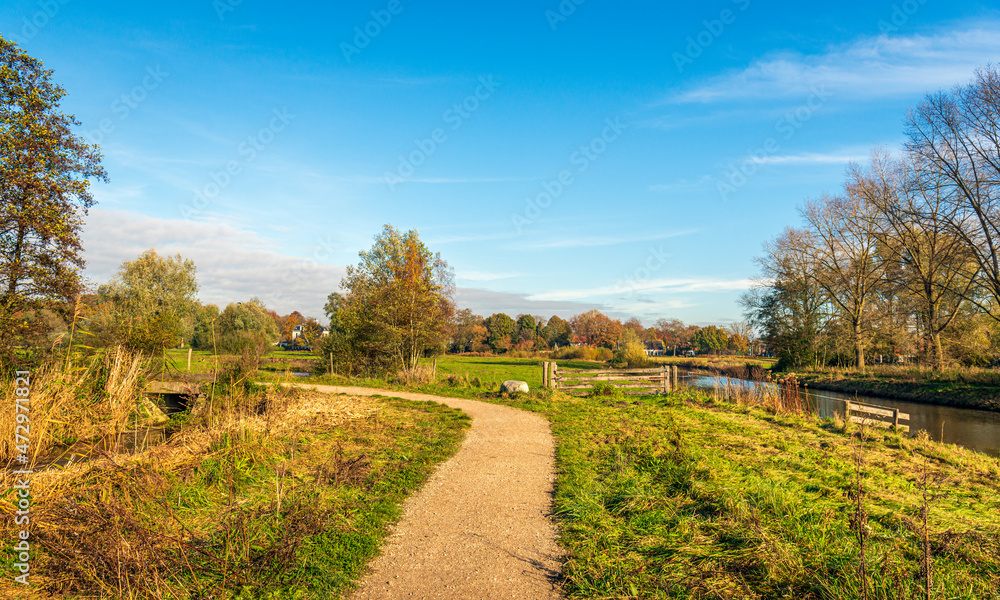 Picturesque Dutch landscape with a curved path in the Markdal nature reserve near the city of Breda, province of North Brabant. The photo was taken at the beginning of a sunny day in the autumn season Picturesque Dutch landscape with a curved path in the Markdal nature reserve near the city of Breda, province of North Brabant. The photo was taken at the beginning of a sunny day in the autumn season