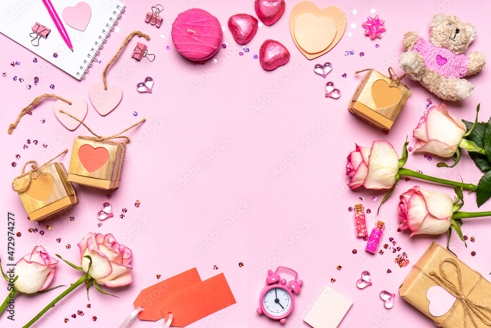 Happy Valentine's day. Frame made of roses flowers, hearts, gifts and decorative items in pink pastel colors on pink background. Greeting card for Valentine's day. Flat lay, top view, copy space