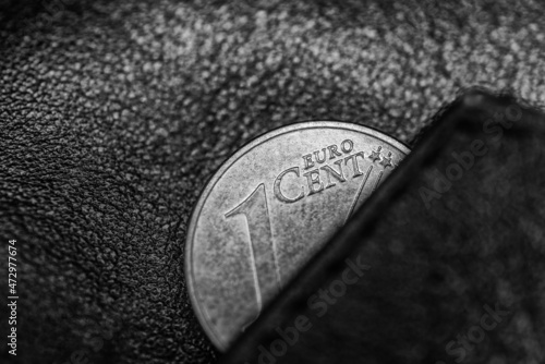 Dark black and white photo of black leather wallet and one cent of euro, to symbolize poverty, bankrupt or thrift, frugality and economy